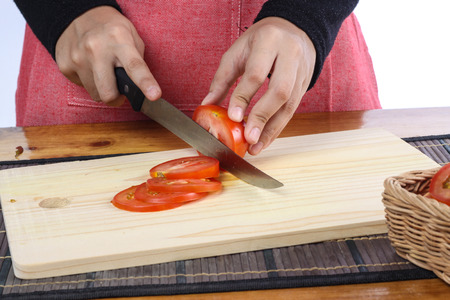tomatoes cut by a kitchen knife on a wooden boardの写真素材