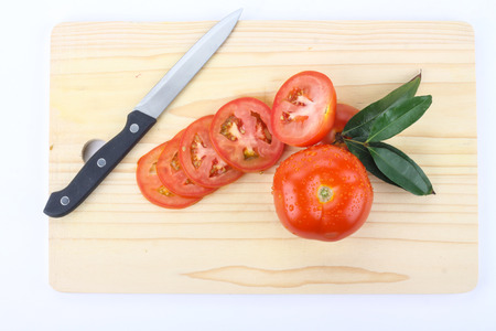 tomatoes cut by a kitchen knife on a wooden boardの写真素材