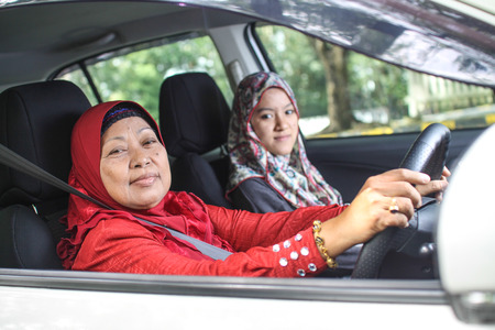 two muslim woman smiling in the carの写真素材