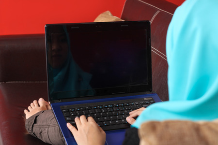 young muslim women relaxing on the sofa with laptopの写真素材