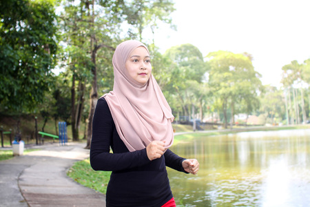 young muslim women was jogging around the lake in the morning with happy face reactionの写真素材
