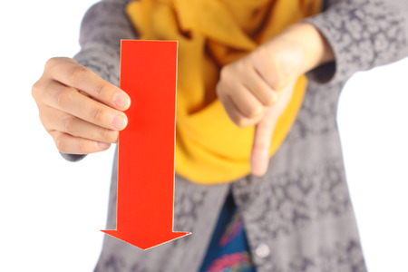 female hand holds red arrow and showing thumbs down signの写真素材
