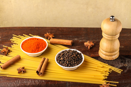 spices with spaghetti isolated on wooden backgroundの写真素材