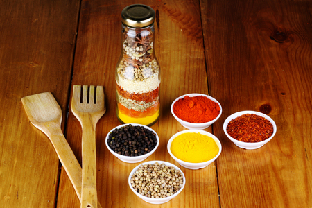 mixed spices and herb in a bottle with wood backgroundの写真素材