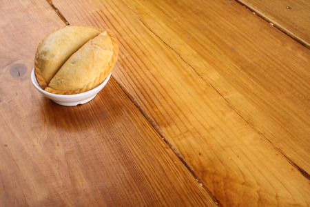 delicious Malaysian curry puff served on white plate on wood backgroundの写真素材
