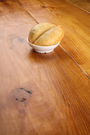 delicious Malaysian curry puff served on white plate on wood backgroundの写真素材
