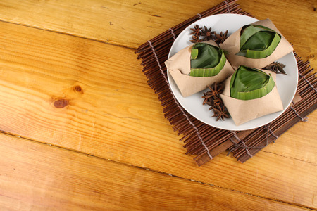 traditional fresh Malaysian nasi lemak packed with banana leaf in wood backgroundの写真素材