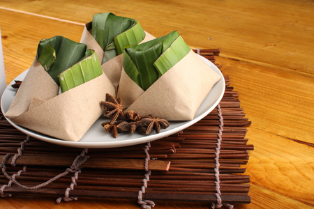 traditional fresh Malaysian nasi lemak packed with banana leaf in wood backgroundの写真素材