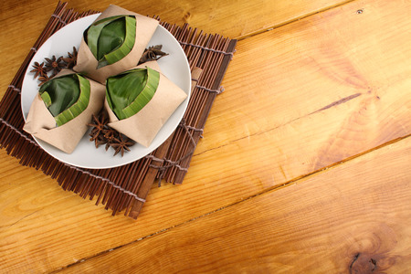 traditional fresh Malaysian nasi lemak packed with banana leaf in wood backgroundの写真素材