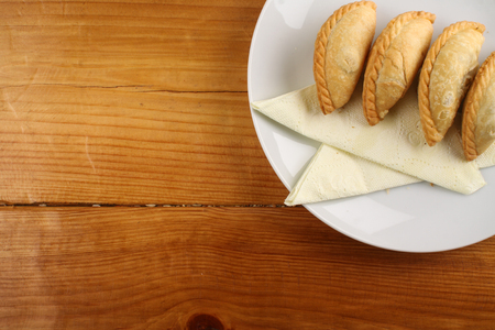 delicious Malaysian curry puff served on white plate on wood backgroundの写真素材