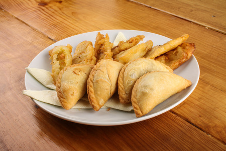 delicious Malaysian curry puff and crispy fried banana served on white plate on wood backgroundの写真素材