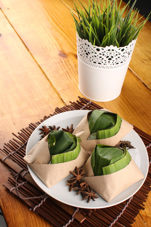 traditional fresh Malaysian nasi lemak packed with banana leaf in wood backgroundの写真素材
