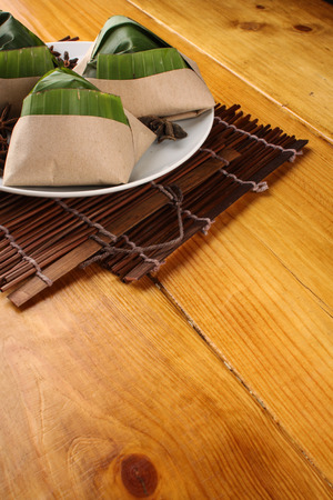traditional fresh Malaysian nasi lemak packed with banana leaf in wood backgroundの写真素材