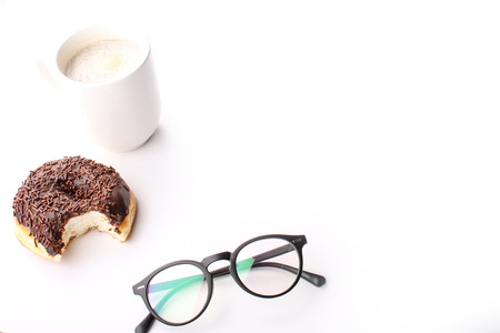 chocholate doughnuts been eaten concept with spectacles and a hot drink in the frameの写真素材