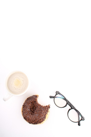 chocholate doughnuts been eaten concept with spectacles and a hot drink in the frameの写真素材