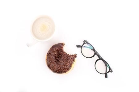 chocholate doughnuts been eaten concept with spectacles and a hot drink in the frameの写真素材