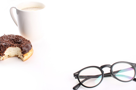 chocholate doughnuts been eaten concept with spectacles and a hot drink in the frameの写真素材