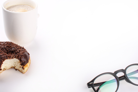 chocholate doughnuts been eaten concept with spectacles and a hot drink in the frameの写真素材