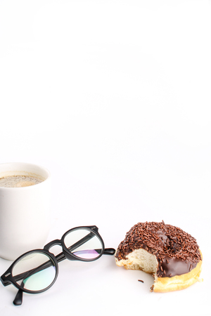 chocholate doughnuts been eaten concept with spectacles and a hot drink in the frameの写真素材