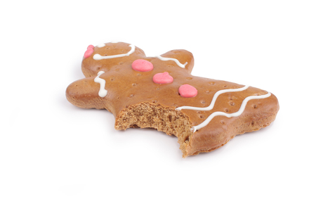 Eaten Gingerbread lady decorated colored icing. Holiday cookie in shape of  lady isolated in white backgroundの写真素材