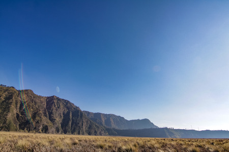 mount penanjakan with brown grass in the foregroundの写真素材
