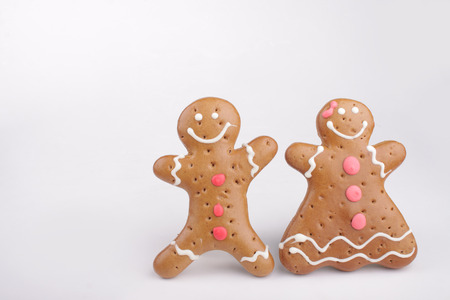 Gingerbread man and Gingerbread lady decorated colored icing. Holiday cookie in shape of man and lady isolated in white backgroundの写真素材