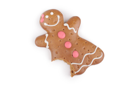 Eaten Gingerbread lady decorated colored icing. Holiday cookie in shape of  lady isolated in white backgroundの写真素材