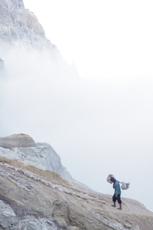 IJEN, INDONESIA - November 18 : A Penambang or Pengangkut Beliran at Ijen crater carrying raw sulfur stone to local dealer. Sulfur mining is one of the main income for the local at Ijen crater 18 November 2015のeditorial素材
