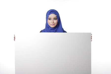 Malaysian asian malay woman holding an empty white board for content space isolated in whiteの写真素材