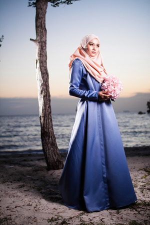 muslim woman posing for fashion with beautiful sunset viewの写真素材