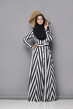 Asian muslimah woman with beautiful attire on gray backgroundの写真素材