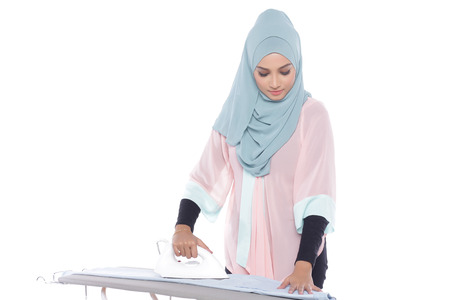 beautiful asian muslimah woman ironing in white backgroundの写真素材