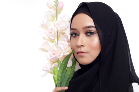 beautiful asian musliman woman with a pink flower on white backgroundの写真素材