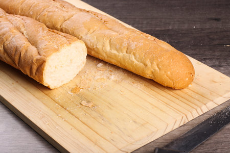 close up view of loaf bread cut with knife on wooden cutting table