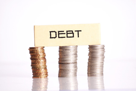 Debt words on top of coins isolated on white backgroundの写真素材