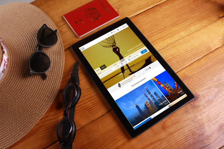 SHAH ALAM , 7 OCTOBER 2016. Travel and concept background with a hat , sunglasess, pasport, goggles and  digital tablet show Agoda travel agency.のeditorial素材