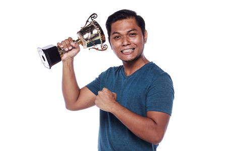 young man holding a trophy isolated on white backgroundの写真素材