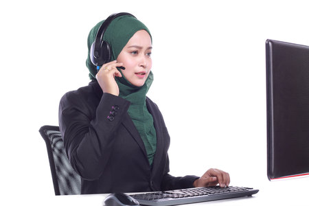 young muslim women helpline operator is trying to hear something through a headphones