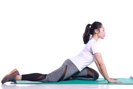 teenage doing yoga poses and work out with yoga mat isolated in whiteの写真素材