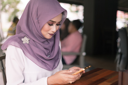 beautiful young woman doing a bussines with her smartphone at cafeの写真素材