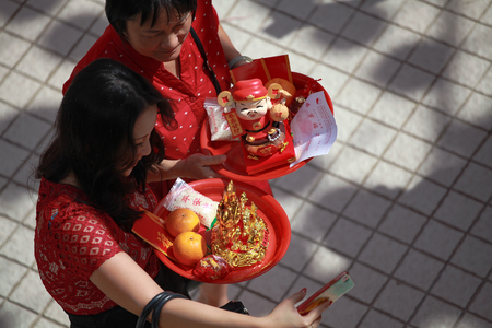 Kuala Lumpur, Malaysia - JANUARY 28, 2017. Woman holding praying stuff at Thean Hou Temple during Chinese New Year celebration.のeditorial素材