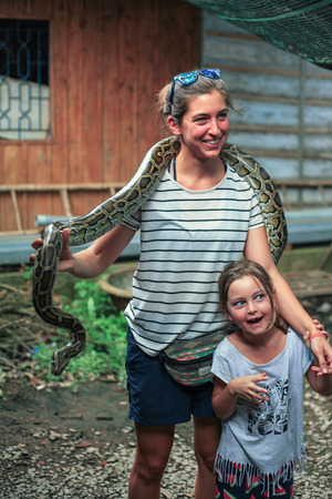 Ho Chi Minh City, Vietnam - 1 January 2018. Tourist holding a large snake at Mekong Delta tours.のeditorial素材
