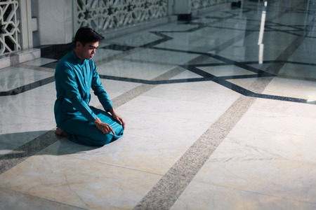 muslim doing religious praying at mosque with sunset flare in frameの写真素材