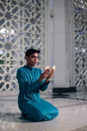 muslim doing religious praying at mosque with sunset flare in frameの写真素材
