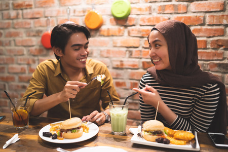 muslim couple breaking fast duing the month of ramadhan at cafeの写真素材