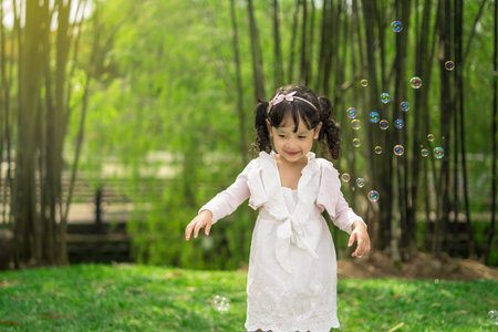 beautiful young asian malay doughter playing with bubble in morning mood