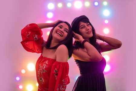 asian teenage having fun at party with neon backgroundの写真素材