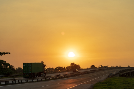 big lorry trailer transportation in a highway sunset viewの写真素材