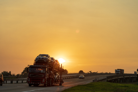 big lorry trailer transportation in a highway sunset viewの写真素材