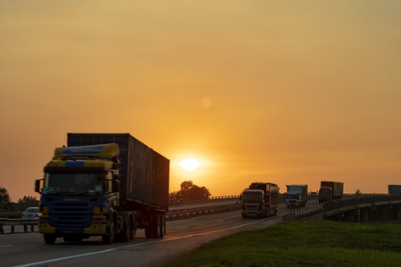 big lorry trailer transportation in a highway sunset viewの写真素材